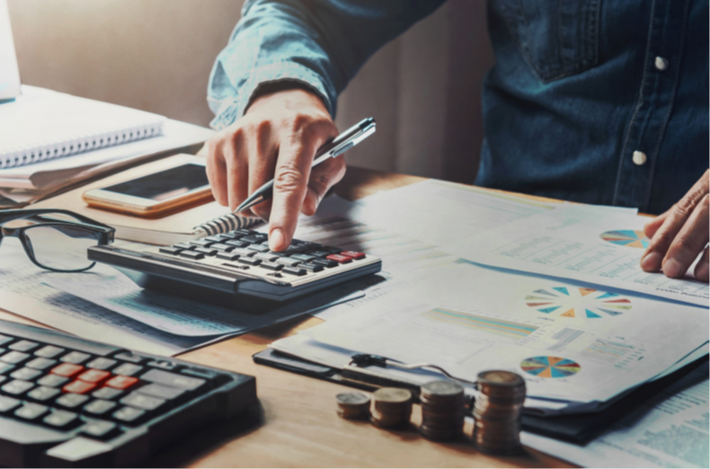 Person reviewing financial documents with a calculator